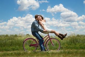 自転車で二人乗りしてデートする男女のカップル